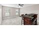 Carpeted bar area with a built-in bar, two windows, and a ceiling fan at 3104 Umbrella Tree Dr, Edgewater, FL 32141