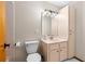 Bathroom featuring a pink vanity, toilet, and a square mirror with globe lighting above at 3104 Umbrella Tree Dr, Edgewater, FL 32141