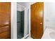 Bathroom featuring a blue tiled shower with glass door and wood paneling at 3104 Umbrella Tree Dr, Edgewater, FL 32141