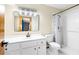 Bathroom featuring a white vanity, toilet, tile shower, and rectangular mirror with globe lighting at 3104 Umbrella Tree Dr, Edgewater, FL 32141