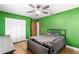 Bedroom features green walls, wood floors, ceiling fan, and closet with white bi-fold doors at 3104 Umbrella Tree Dr, Edgewater, FL 32141