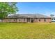 Classic brick single story home featuring a well-maintained lawn and a mature shade tree at 3104 Umbrella Tree Dr, Edgewater, FL 32141
