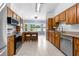 This eat-in kitchen features stainless appliances, tile flooring, breakfast bar, and backyard views at 3104 Umbrella Tree Dr, Edgewater, FL 32141
