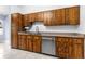 Kitchen featuring stainless steel dishwasher, tile flooring, and wood cabinetry at 3104 Umbrella Tree Dr, Edgewater, FL 32141