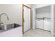 Bright laundry room features a stainless steel sink, tile flooring, and washer and dryer at 3104 Umbrella Tree Dr, Edgewater, FL 32141