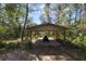 Lawnmower parked in a carport surrounded by dense trees at 3211 Hidden Crest Ln, Deland, FL 32724