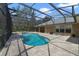 Backyard screened-in pool with brick pavers and lush greenery at 3211 Hidden Crest Ln, Deland, FL 32724
