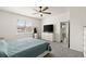 Sunlit bedroom featuring neutral tones, plush carpeting, ceiling fan, and a dresser with a large television at 322 E Merimont Ln, Ormond Beach, FL 32174