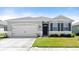 Charming single-story home with a two-car garage, gray exterior and well-maintained front lawn at 322 E Merimont Ln, Ormond Beach, FL 32174