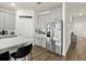 Well-appointed kitchen features gray cabinets, stainless steel refrigerator and island with seating at 322 E Merimont Ln, Ormond Beach, FL 32174