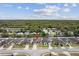 Aerial shot of home in a quiet neighborhood, nestled amongst trees and greenery under a blue sky at 3845 Arborvitae Way, Deland, FL 32724
