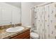 Well-lit bathroom featuring a vanity with granite countertop and shower with floral curtain at 3845 Arborvitae Way, Deland, FL 32724