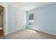 Bedroom with light blue walls, carpet flooring, and a window offering natural light at 3845 Arborvitae Way, Deland, FL 32724