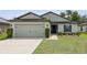 This home features a two car garage, a manicured lawn and landscaping at 3845 Arborvitae Way, Deland, FL 32724
