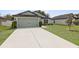 Charming one-story home with a two-car garage, well-manicured lawn, and beautiful landscaping at 3845 Arborvitae Way, Deland, FL 32724