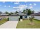 Charming single Gathering home featuring a manicured lawn and an attached two-car garage at 3845 Arborvitae Way, Deland, FL 32724