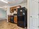 Kitchen featuring wood cabinets, granite countertops, and black appliances and refrigerator at 3845 Arborvitae Way, Deland, FL 32724