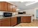 Well-lit kitchen features wood cabinets, granite countertops, a microwave, dishwasher, and wood-look flooring at 3845 Arborvitae Way, Deland, FL 32724