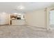 Open-concept living room with neutral tones and carpet flooring adjacent to kitchen area at 3845 Arborvitae Way, Deland, FL 32724