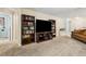 Cozy living room featuring carpeted floors, large bookshelves, and ample space for entertaining and relaxation at 3845 Arborvitae Way, Deland, FL 32724
