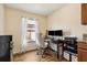 Bright home office space features modern computer setup, neutral walls, light-filtering curtains and wood-look floors at 3845 Arborvitae Way, Deland, FL 32724