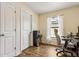 Bright office includes modern computer setup, neutral walls, light-filtering curtains, water cooler and wood-look floors at 3845 Arborvitae Way, Deland, FL 32724