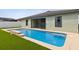 A detailed view of the pool with steps, the sliding glass door to the house, and the backyard at 3845 Arborvitae Way, Deland, FL 32724