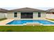 Backyard view showcasing a refreshing swimming pool, patio, and surrounding green lawn at 3845 Arborvitae Way, Deland, FL 32724