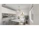 Bright dining area features white table set for six next to open kitchen with bar top and modern chandelier at 411 N Halifax Ave # 304, Daytona Beach, FL 32118