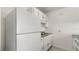 Compact kitchen features white appliances, white cabinets, a stainless sink, and lots of storage space at 411 N Halifax Ave # 304, Daytona Beach, FL 32118
