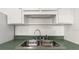 Kitchen sink features stainless steel fixtures, ample counter space, and a storage shelf above at 411 N Halifax Ave # 304, Daytona Beach, FL 32118