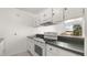 Compact kitchen features white appliances, lots of cabinet space, and a breakfast bar with outdoor views at 411 N Halifax Ave # 304, Daytona Beach, FL 32118