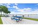 Waterfront picnic area featuring blue picnic tables, charcoal grills, and beautiful scenic views at 411 N Halifax Ave # 304, Daytona Beach, FL 32118