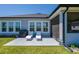 Backyard patio with lounge chairs, a grill, and a view of the screened-in lanai, perfect for relaxation and outdoor entertainment at 418 Aquamarine Way, Daytona Beach, FL 32124