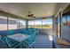 Cozy screened patio with comfortable seating, ceiling fan, and views of the lush backyard, creating a relaxing retreat at 418 Aquamarine Way, Daytona Beach, FL 32124