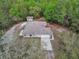 Aerial shot of the residence, showing the home's layout, roof, and surrounding dense greenery at 4600 S Tomoka Dr, De Leon Springs, FL 32130