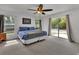 Serene main bedroom with plush carpet, ceiling fan, and outdoor access at 4600 S Tomoka Dr, De Leon Springs, FL 32130