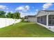View of a spacious and private, fenced backyard featuring a lush lawn, mature trees, and a peaceful patio area at 484 Sherwood Oaks Rd, Orange City, FL 32763
