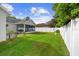 Enjoy a large backyard with a white privacy fence, mature trees, a lush lawn, and a covered screened patio at 484 Sherwood Oaks Rd, Orange City, FL 32763