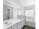 Bright bathroom with double sink vanity, modern fixtures, and a soaking tub with a glass block window at 484 Sherwood Oaks Rd, Orange City, FL 32763