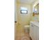 Bathroom with a toilet, sink, and white cabinet and small window at 501 Powers Ave, Port Orange, FL 32127