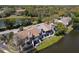 Aerial view of grey townhouses with lake views, mature trees and green space at 509 Lake Bridge Dr, Ormond Beach, FL 32174