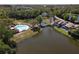 Aerial view of community pool with lake access and walking bridge in a lakeside community at 509 Lake Bridge Dr, Ormond Beach, FL 32174