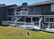 Gray townhouse showing an outdoor patio with white railings and chairs with green space at 509 Lake Bridge Dr, Ormond Beach, FL 32174