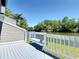 An angled view of a wooden balcony overlooking the waterfront and a small bench at 509 Lake Bridge Dr, Ormond Beach, FL 32174