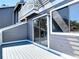 Exterior balcony with grey wood siding and a sliding glass door, overlooking trees and water at 509 Lake Bridge Dr, Ormond Beach, FL 32174