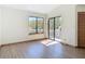 Bright bedroom features hard wood floors, a window and a sliding glass door leading to the balcony at 509 Lake Bridge Dr, Ormond Beach, FL 32174