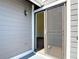 Side angle of entrance to unit with a screen door and grey wood siding at 509 Lake Bridge Dr, Ormond Beach, FL 32174