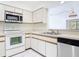 Bright kitchen with white cabinets, stainless steel appliances and an open view to the living room at 509 Lake Bridge Dr, Ormond Beach, FL 32174