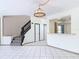 Open-concept living area with tile flooring, pass-through to kitchen, and staircase at 509 Lake Bridge Dr, Ormond Beach, FL 32174